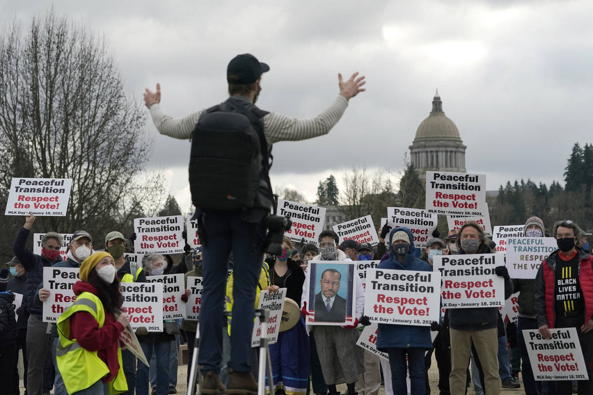 People hold signs as they assemble for a group photo following a vigil supporting a peaceful tr ...