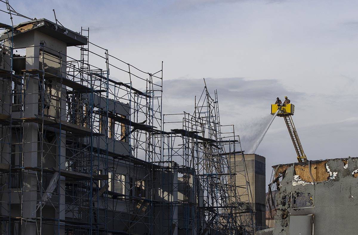 Clark County firefighters spray water at an under-construction Ely at Fort Apache apartment com ...