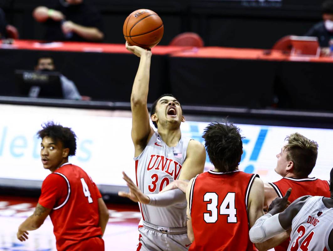 UNLV Rebels forward Devin Tillis (30) gets fouled by Benedictine Mesa Redhawks Tyler Fernstrom ...