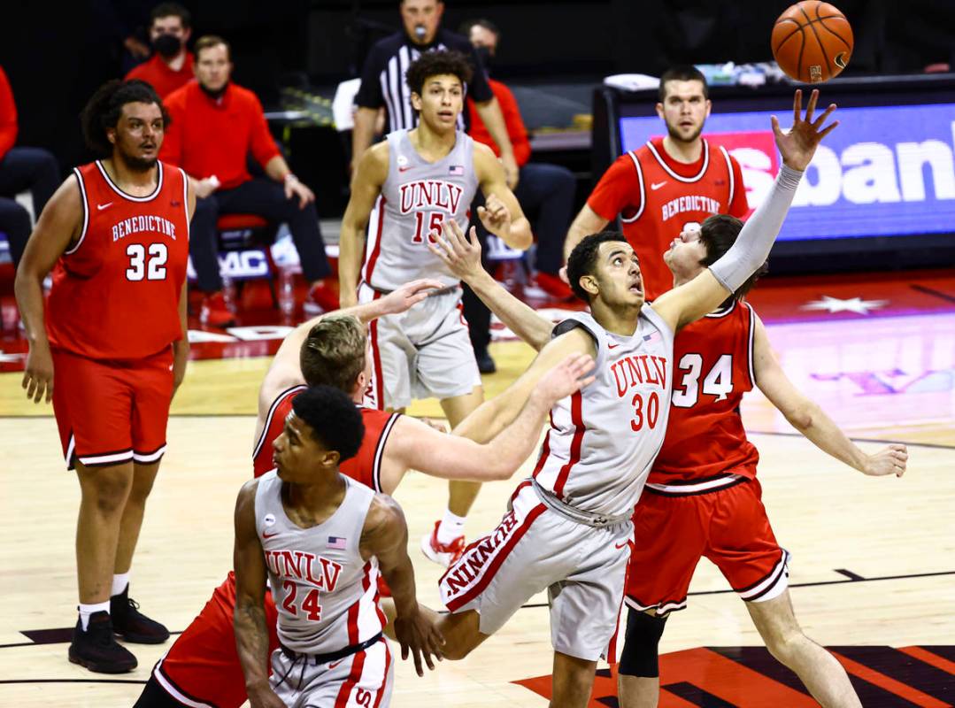 UNLV Rebels forward Devin Tillis (30) reaches for a rebound against the Benedictine Mesa Redhaw ...