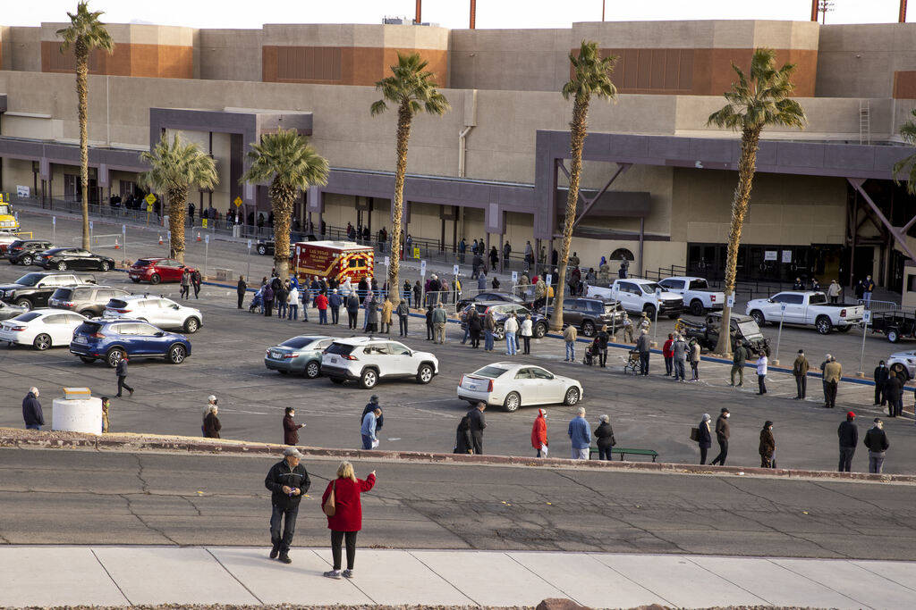People wait in a long line in the parking lot at the Cashman Center for COVID-19 vaccinations o ...