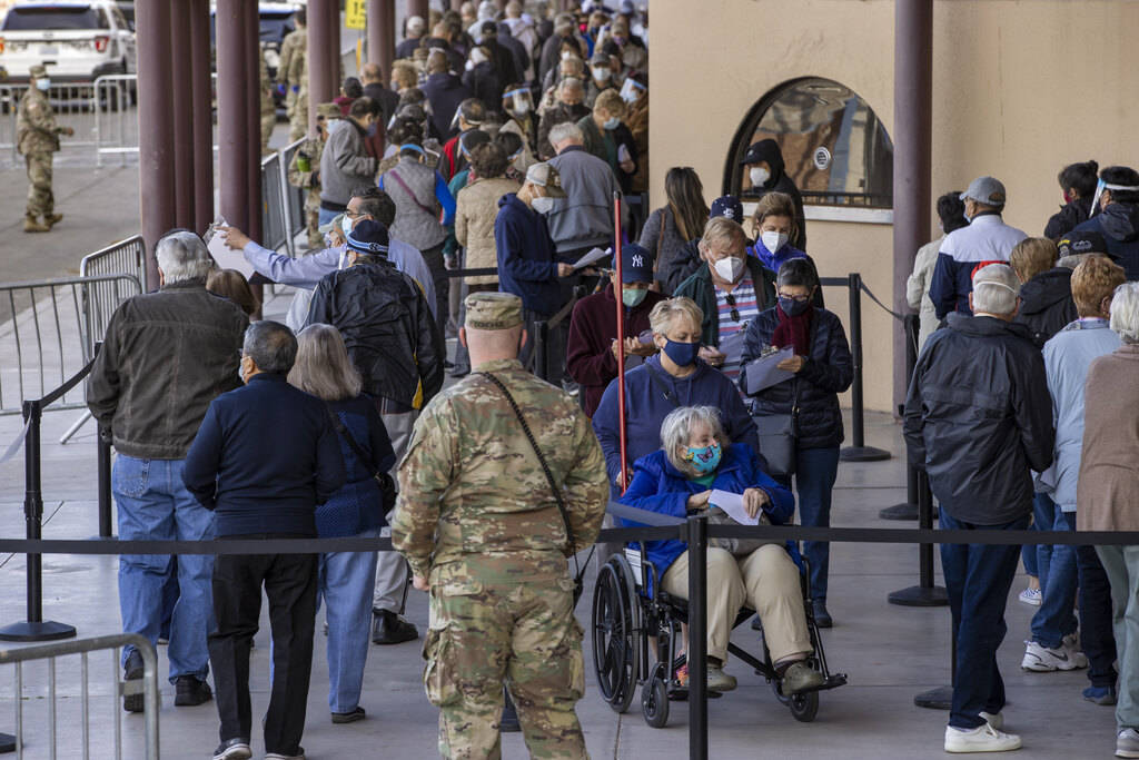 People move along while in line to enter the Cashman Center for COVID-19 vaccinations operated ...
