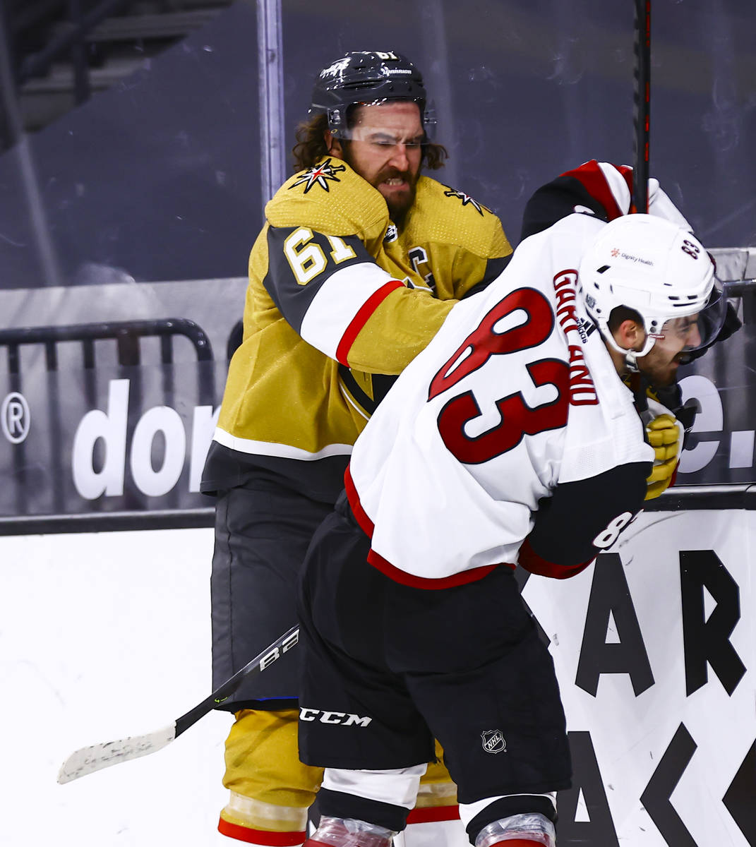 Golden Knights right wing Mark Stone (61) hits Arizona Coyotes right wing Conor Garland (83) du ...