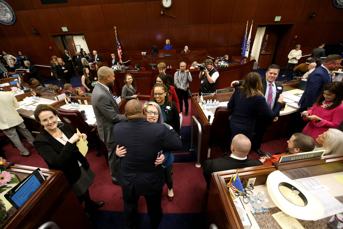 Assembly Speaker Jason Frierson, D-Las Vegas, hugs Sarah Peters, D-Reno, as female lawmakers wa ...