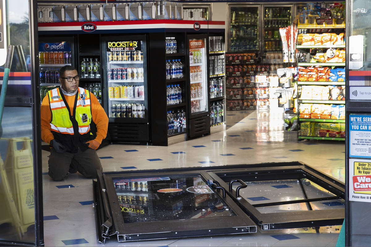 A worker surveys damage after a man who got into an argument with a convenience store clerk dro ...