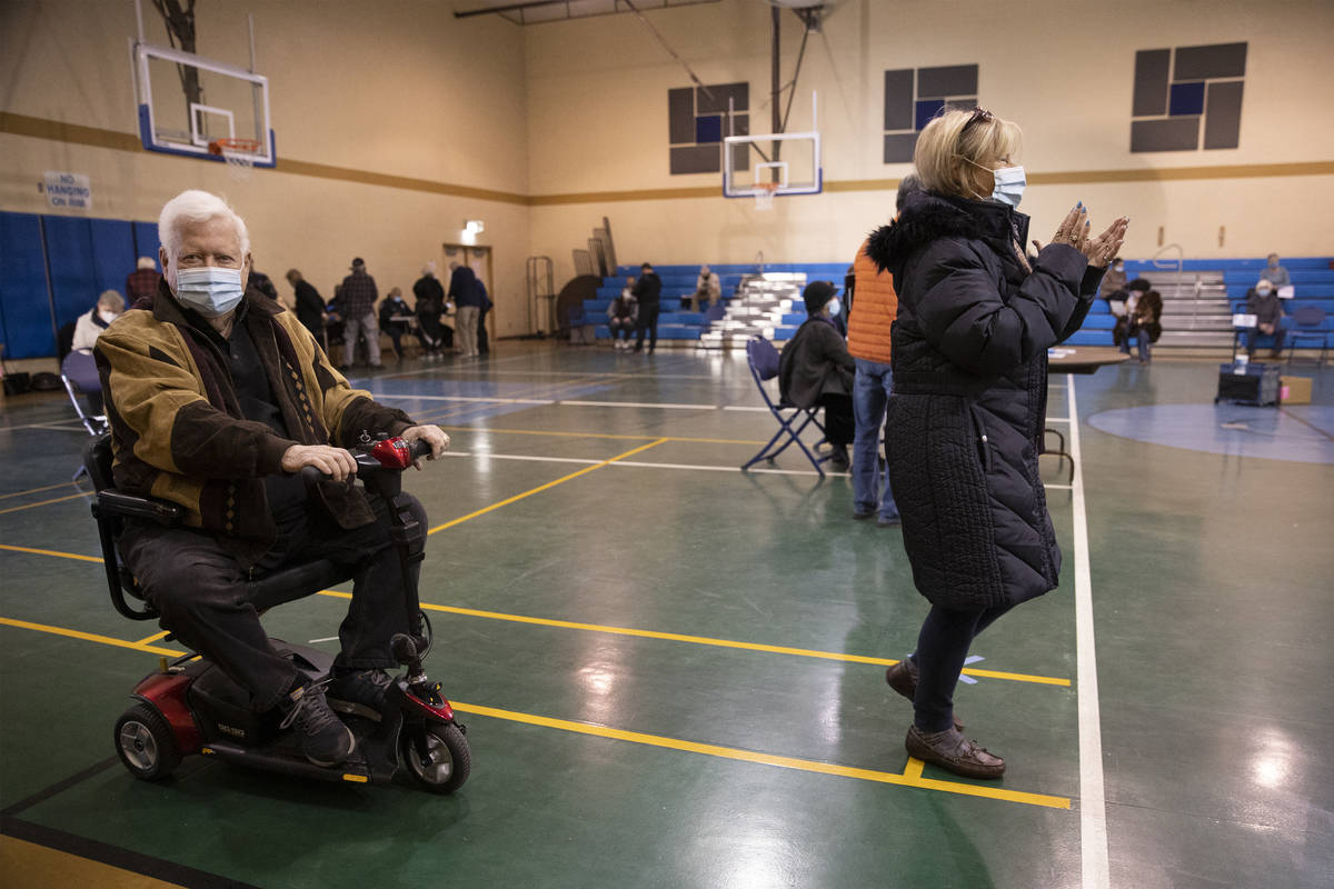 Richard Lober, left, 79, and his wife Lynne, 70, get in line to receive the COVID-19 vaccine at ...