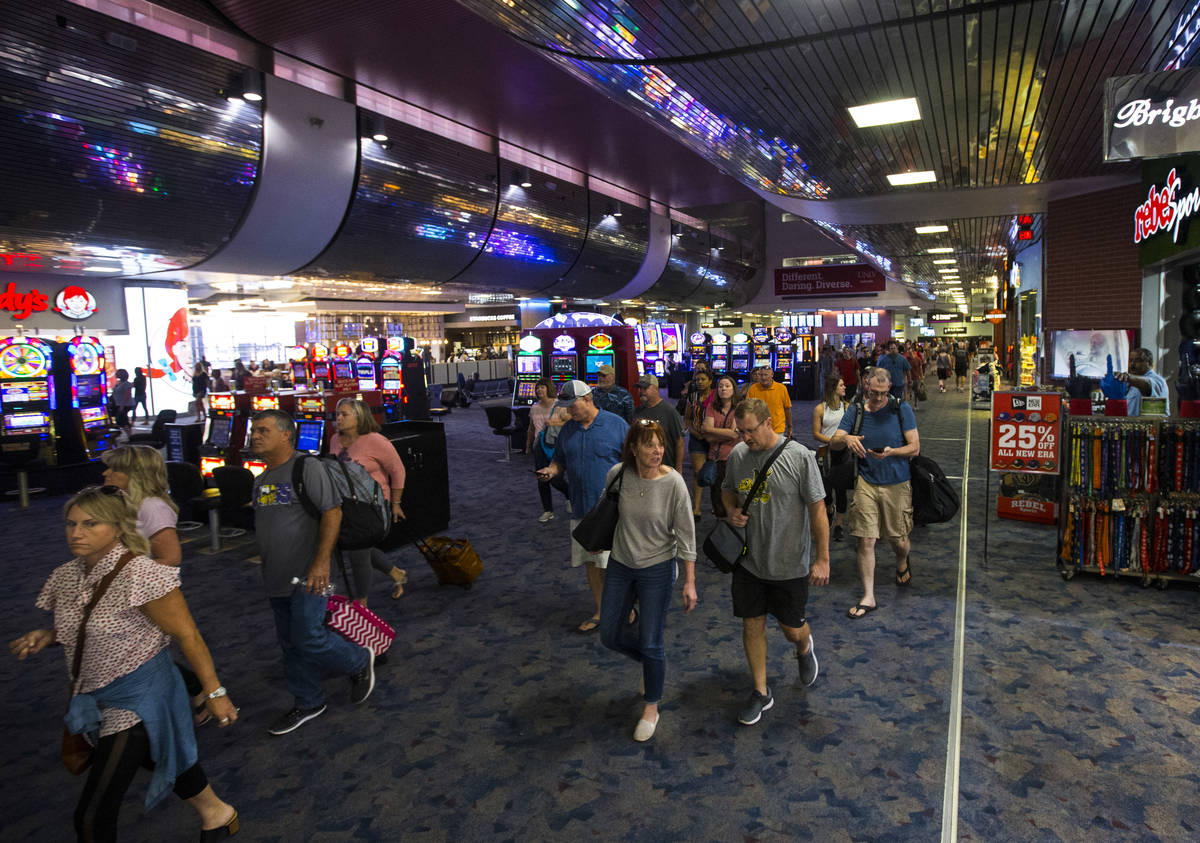 Passengers make their way to baggage claim and transportation at McCarran International Airport ...