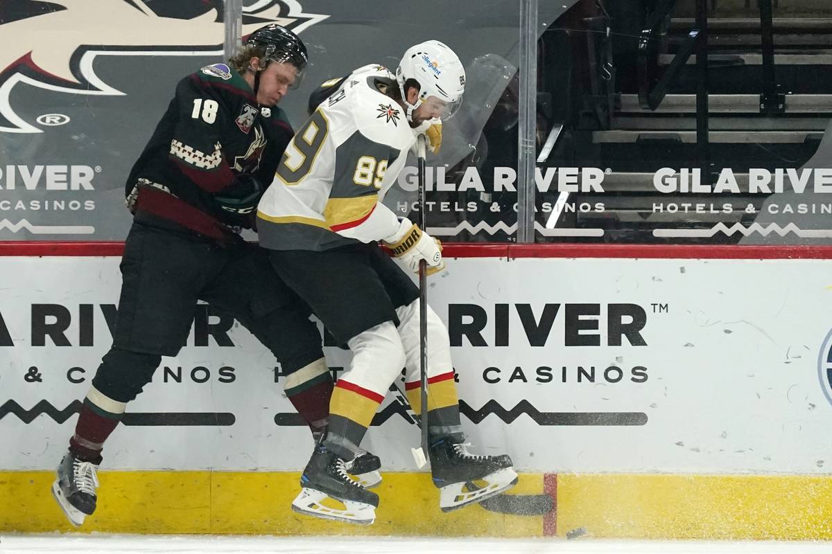 Arizona Coyotes center Christian Dvorak (18) battles with Vegas Golden Knights right wing Alex ...