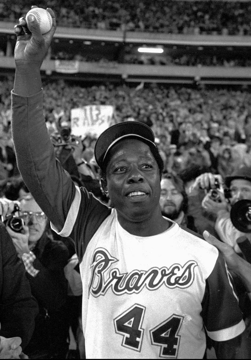 FILE – In this April 8, 1974, file photo, Atlanta Braves' Hank Aaron holds  aloft the ball he hi …
