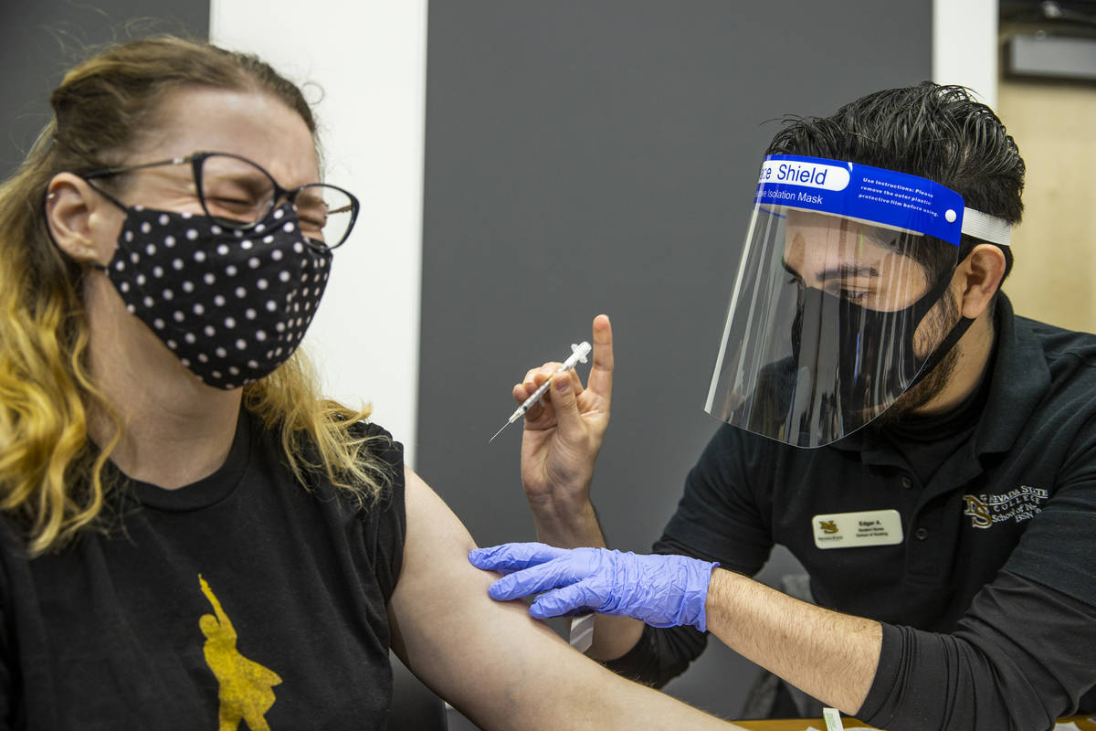 Medical worker Jennifer Gorden, left, winces a little as Nevada State College School of Nursing ...