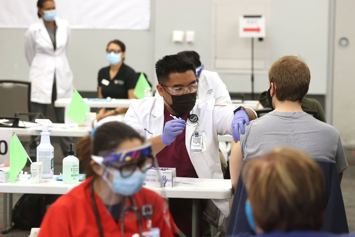Medical student Michael Briones gives a COVID-19 vaccine during a UNLV Medicine clinic in the S ...
