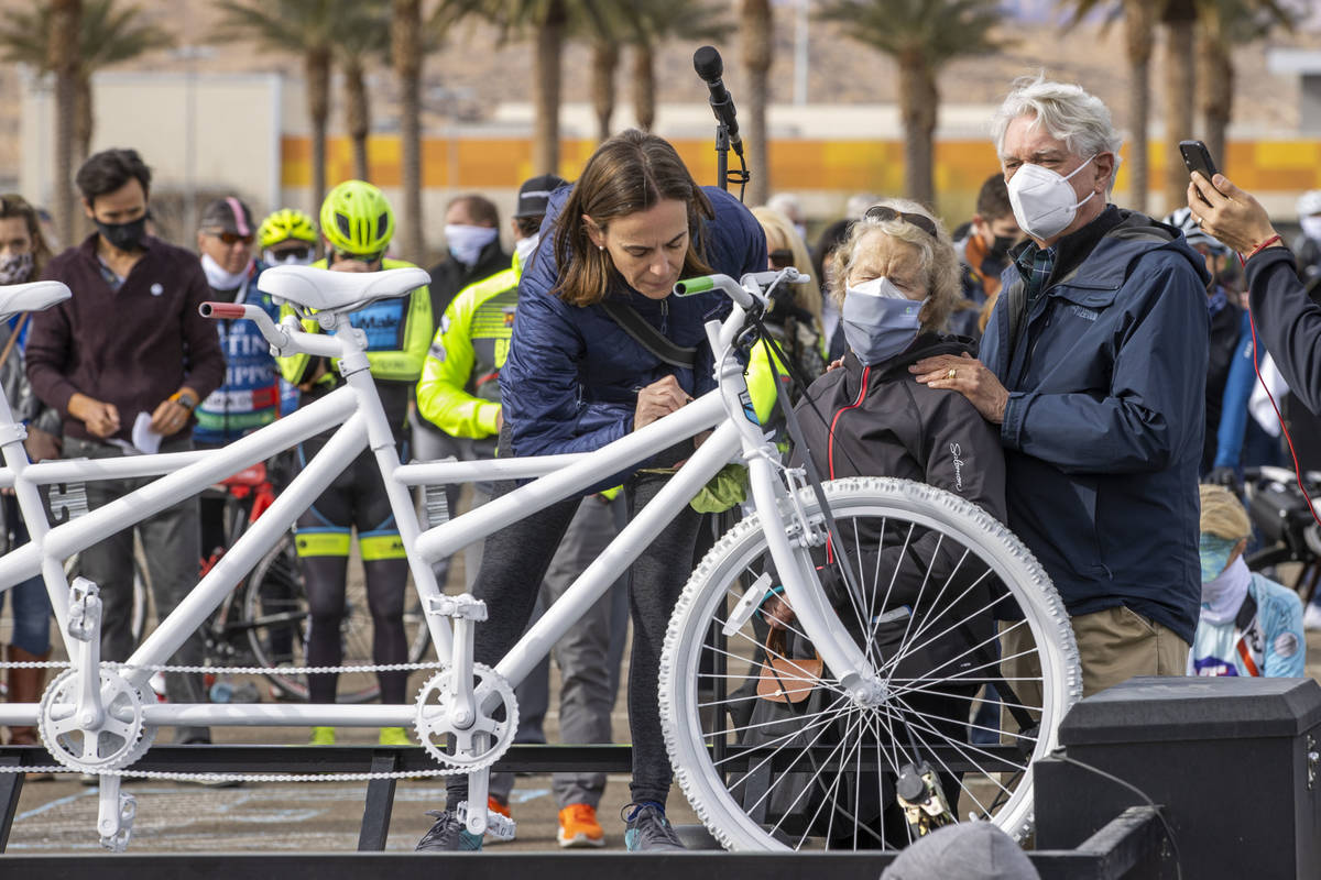 Donna Trauger, left, signs the bike for her late husband Tom Trauger as Tom's parents Susan an ...