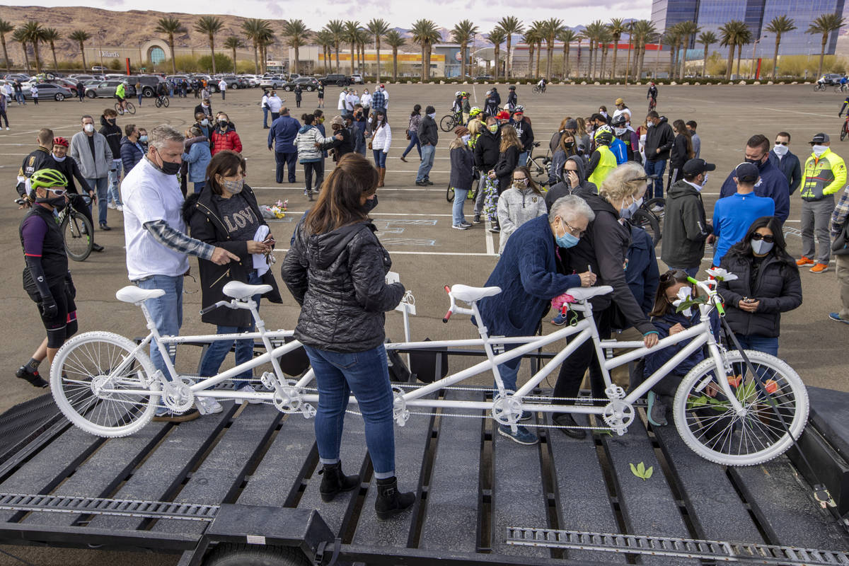 Friends and family sign the Ghost Bike to honor the five cyclists recently killed in Searchligh ...