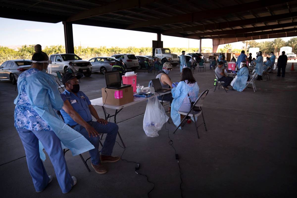 Farm workers receive the Pfizer-BioNTech COVID-19 vaccine at Tudor Ranch in Mecca, Calif., in J ...