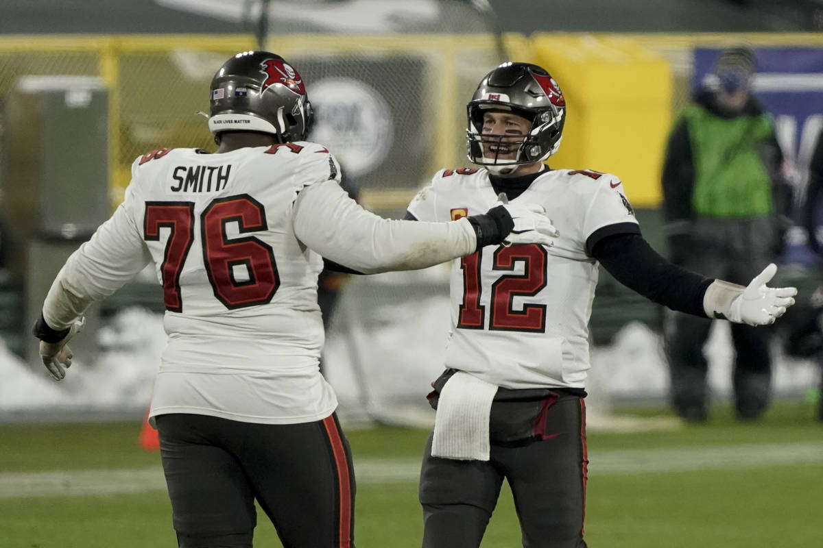 Tampa Bay Buccaneers quarterback Tom Brady celebrates with Donovan Smith after winning the NFC ...