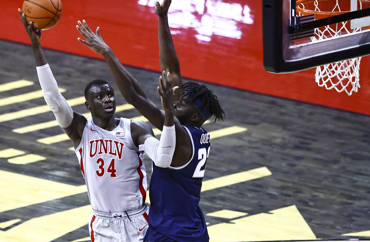 UNLV Rebels forward Cheikh Mbacke Diong (34) shoots around Utah State Aggies center Neemias Que ...