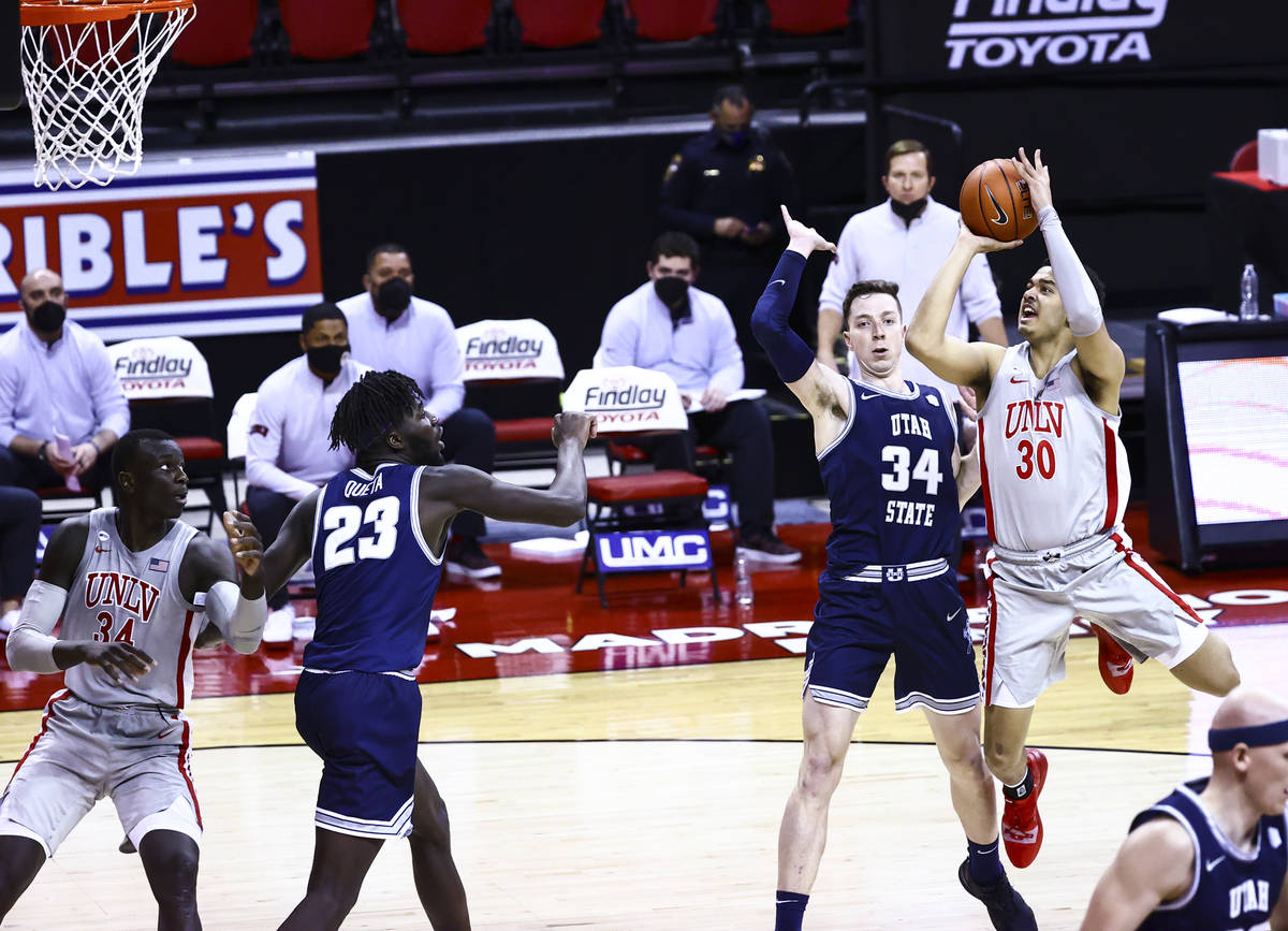 UNLV Rebels forward Devin Tillis (30) shoots over Utah State Aggies forward Justin Bean (34) du ...