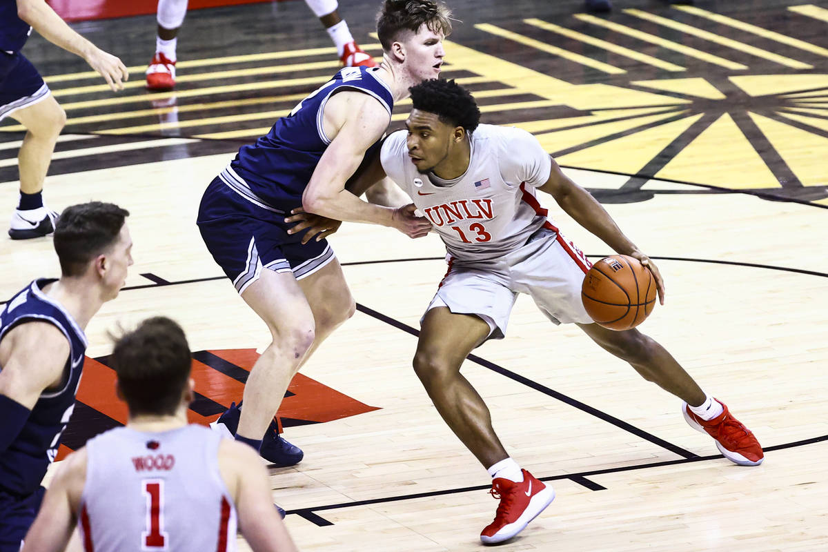 UNLV Rebels guard Bryce Hamilton (13) drives to the basket against Utah State Aggies guard Sean ...