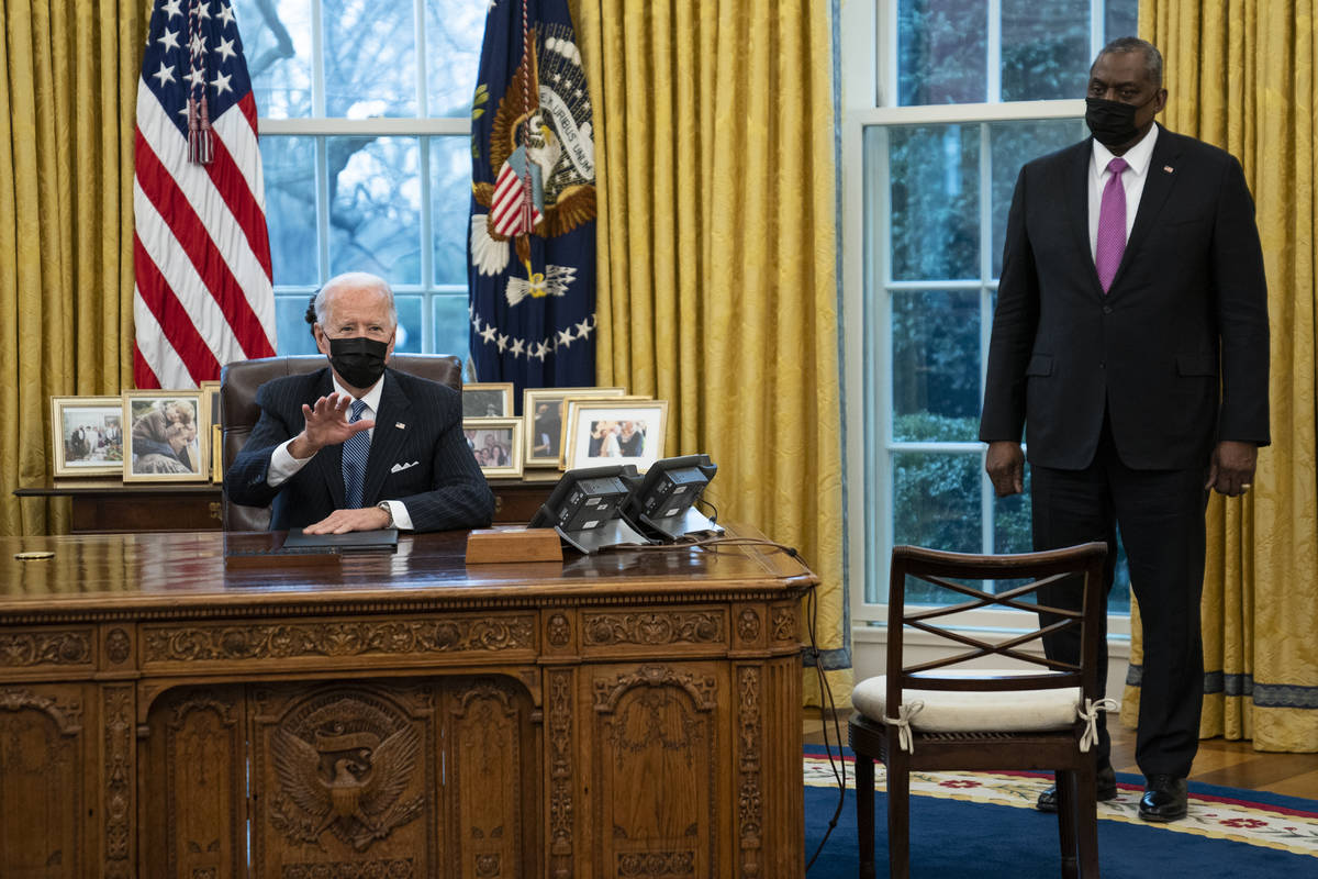Secretary of Defense Lloyd Austin listens as President Joe Biden speaks before signing an Execu ...