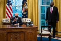 Secretary of Defense Lloyd Austin listens as President Joe Biden speaks before signing an Execu ...