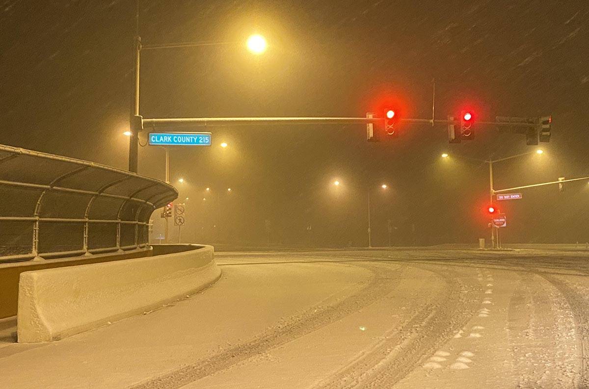 Snow covers much of the intersection at West Lake Mead Boulevard and the 215Beltway before sunr ...