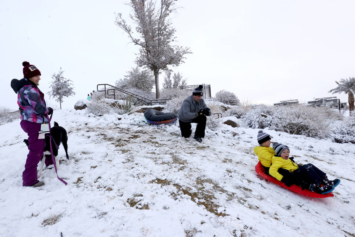 Nicholas Tarantino, 7, left, and his brother, Colton, 5, slide down a hill as their mother Eric ...