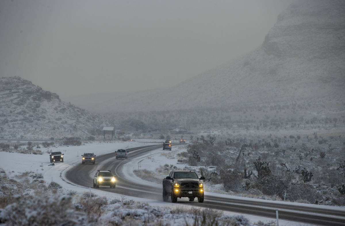 Cars navigate the snowy road in the Red Rock Conservation Area on Tuesday, Jan. 26, 2021, in La ...