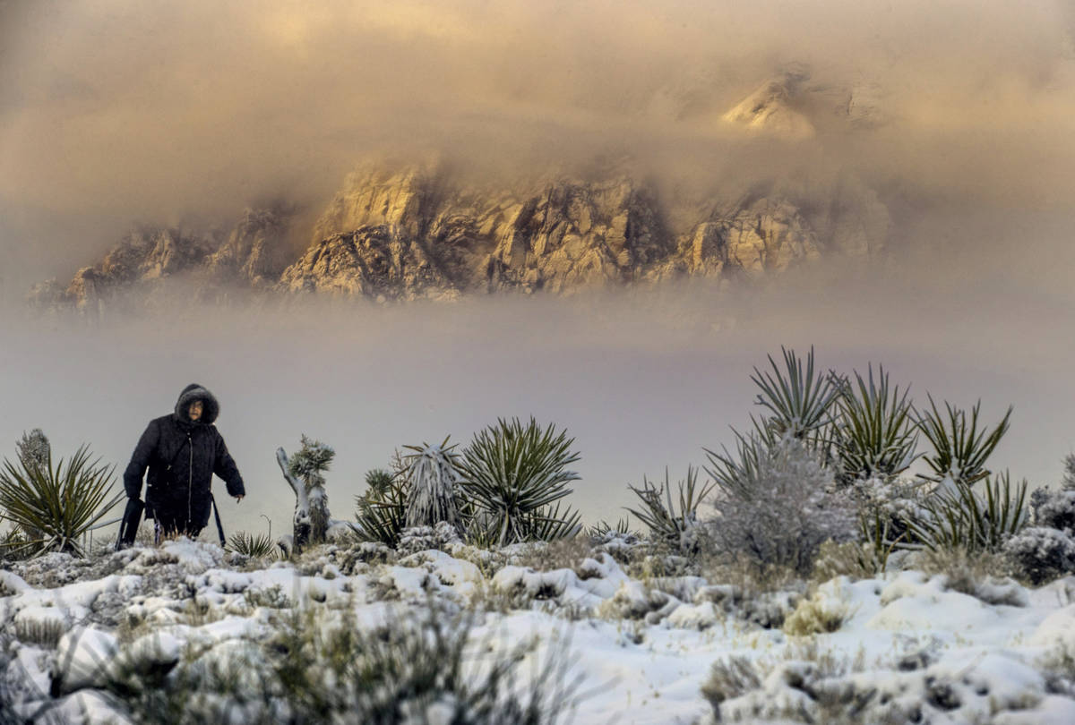 Sylvia Hinojosa hikes up to the overlook as the clouds break on a snowy day in the Red Rock Con ...