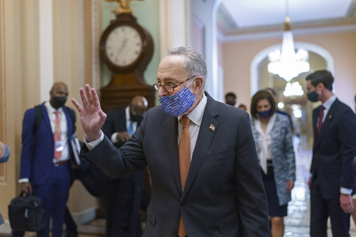On the first full day of Democratic control, Senate Majority Leader Chuck Schumer, D-N.Y., walk ...