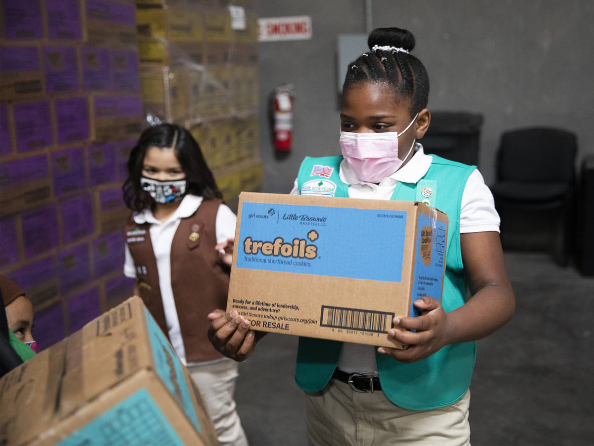 Girl Scout Aliyah H., 9, moves a box of Girl Scout Cookies at the Bekins Moving Solutions wareh ...