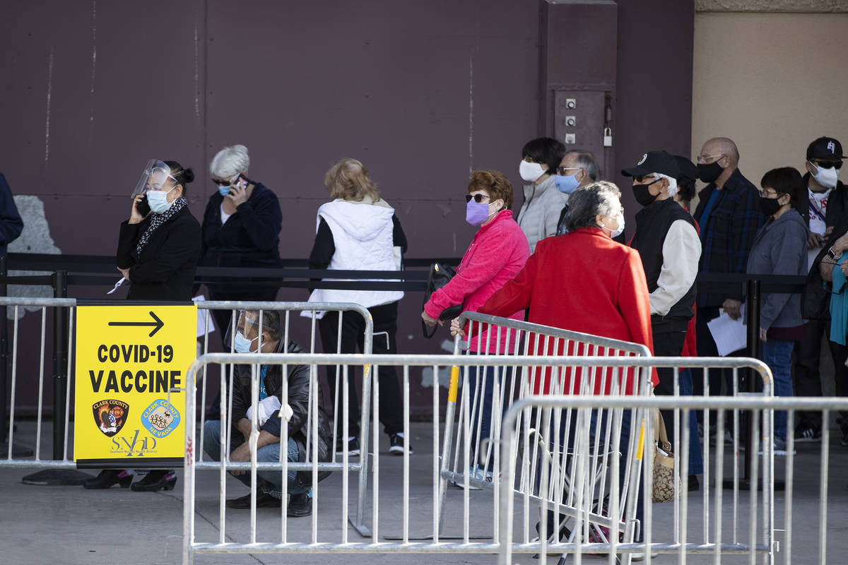 People wait in line to get the COVID-19 vaccine was the Cashman Center in Las Vegas, on Wednesd ...