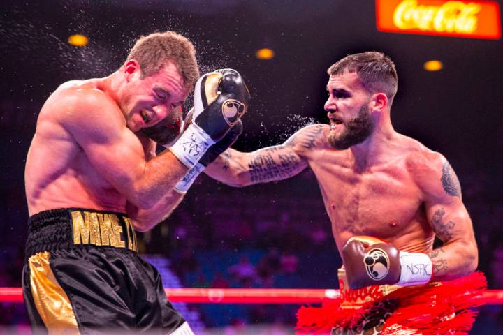 Mike Lee, left, takes a punch to the face from Caleb Plant which sends him to the canvas again ...