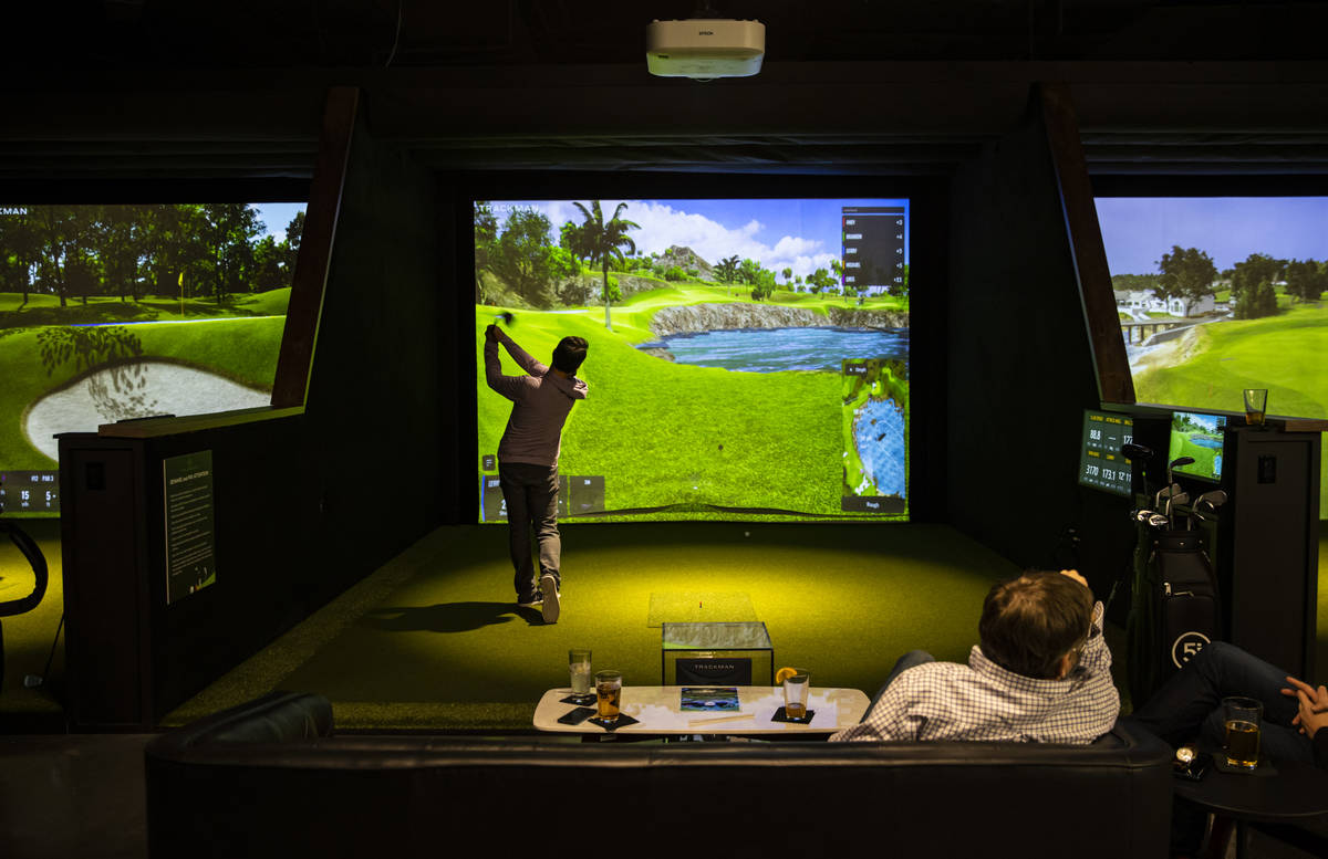 Gerry Montiel, of Henderson, takes a swing during a friends and family event at Five Iron Golf ...