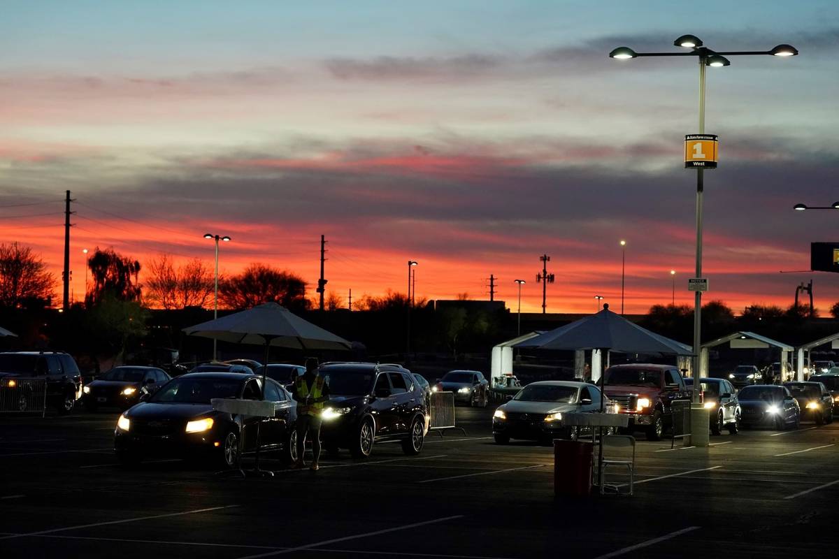 Vehicles wait for COVID-19 vaccination cards during a pre-registered drive-thru event at State ...