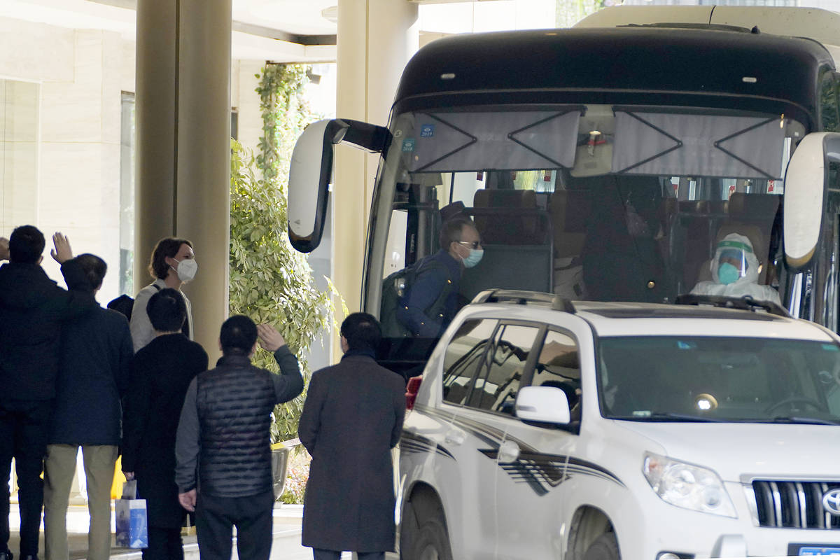 Workers wave to the team of experts from the World Health Organization who ended their quaranti ...