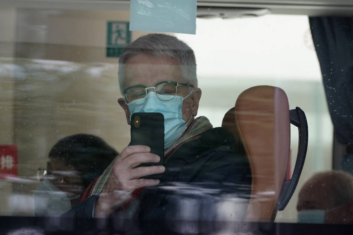 A member from the World Health Organization team of experts uses his smartphone to record the s ...