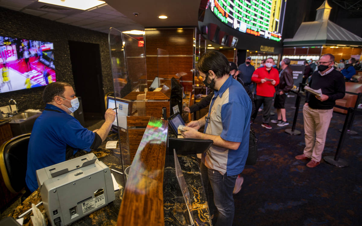 Mike Iannone, left, confers the bets placed by bettor Grayson Hart as the Westgate sportsbook p ...