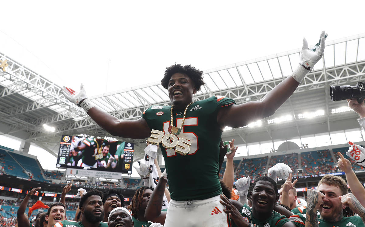 Miami defensive lineman Gregory Rousseau (15) celebrates a turnover and wears the turnover chai ...