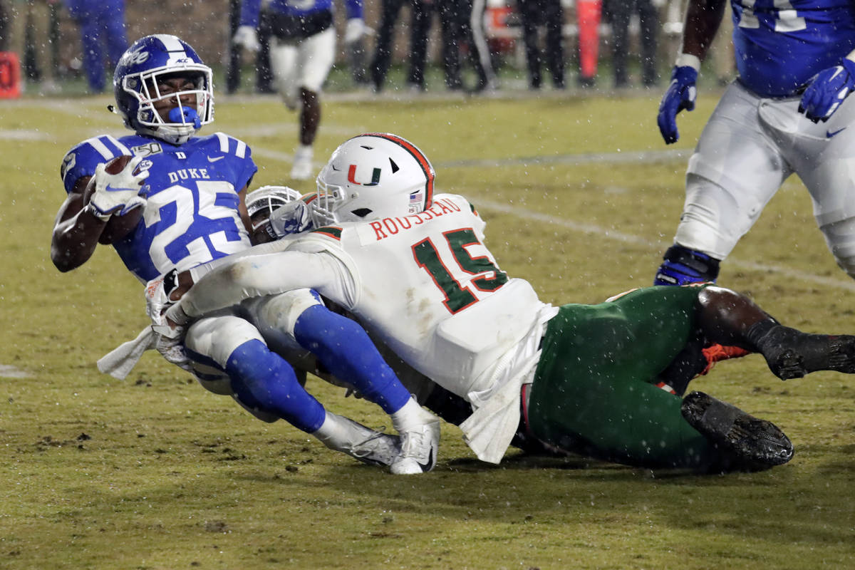 Miami's Gregory Rousseau (15) tackles Duke's Deon Jackson (25) during the second half of an NCA ...