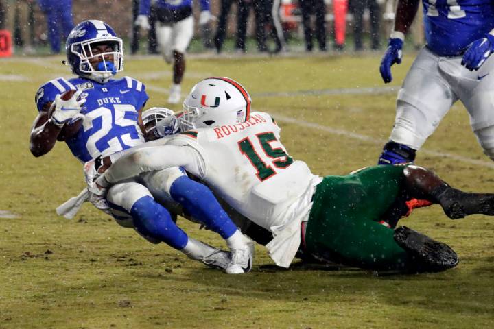 Miami's Gregory Rousseau (15) tackles Duke's Deon Jackson (25) during the second half of an NCA ...