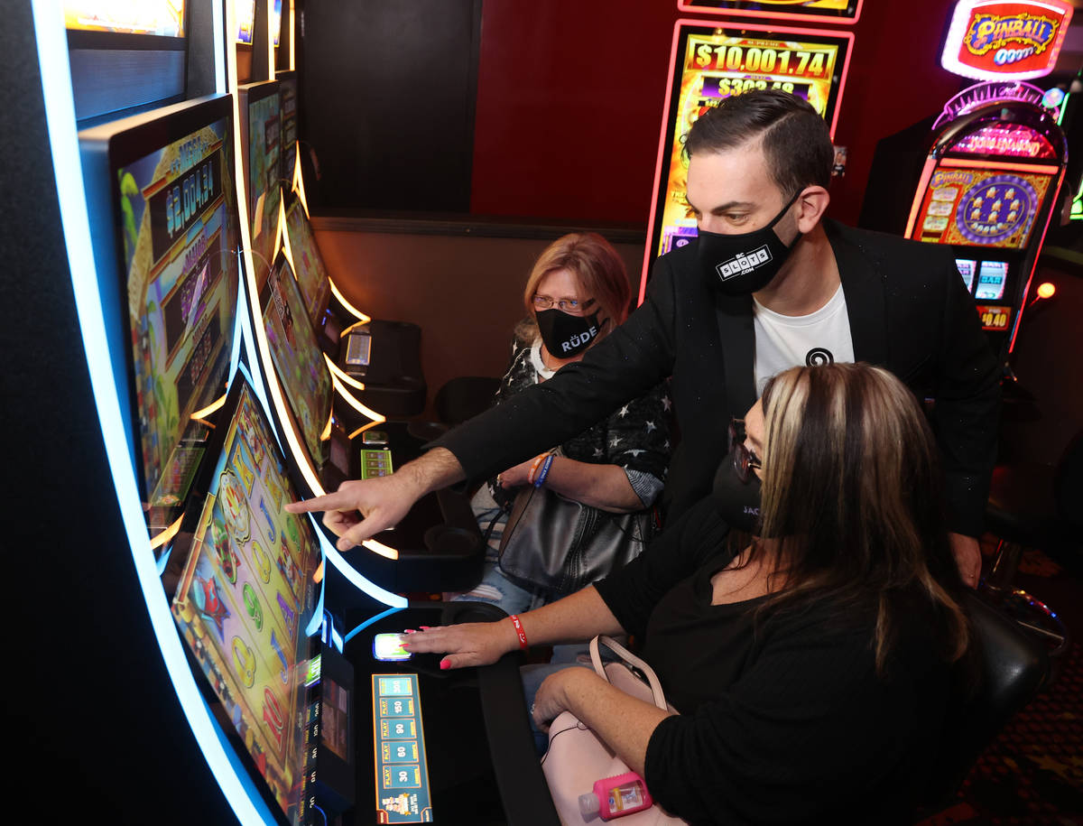 Slot machine YouTuber Brian Christopher teaches Marci Sain, left, and Connie Thomas, both of Ph ...
