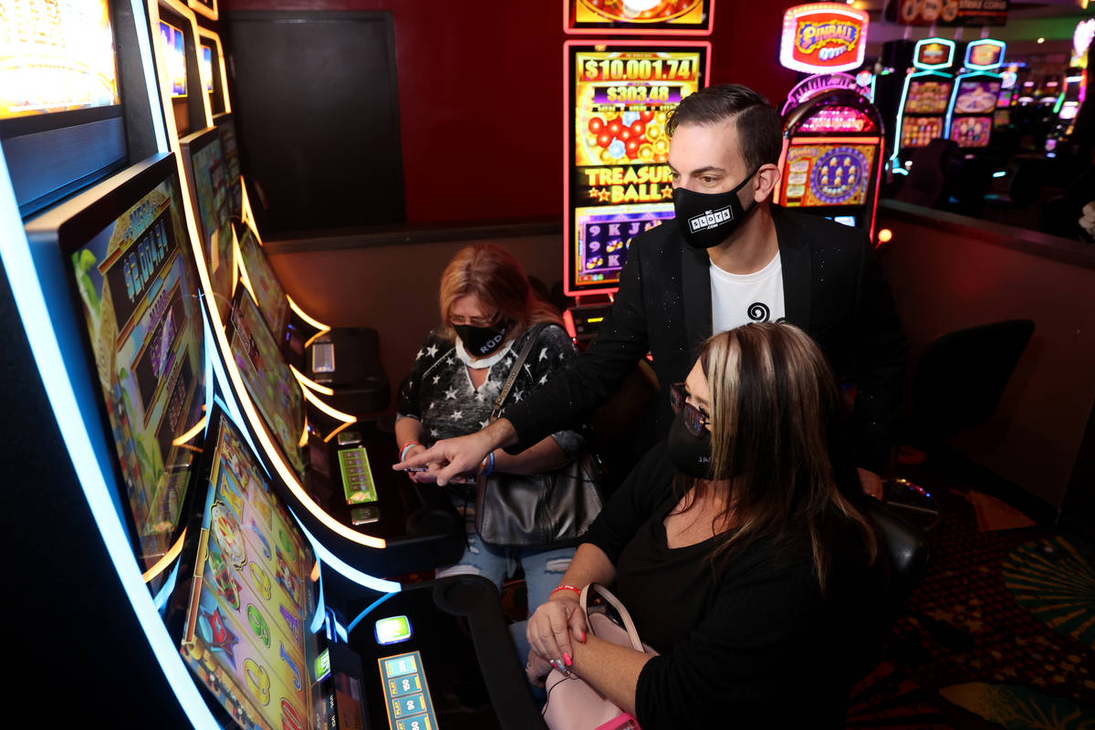 Slot machine YouTuber Brian Christopher teaches Marci Sain, left, and Connie Thomas, both of Ph ...