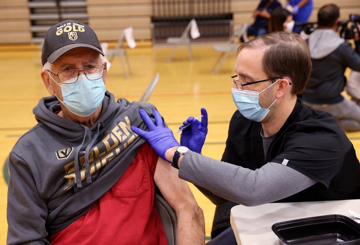 John Reynolds, a registered nurse with Southern Nevada Health District, vaccinates Bill Henning ...
