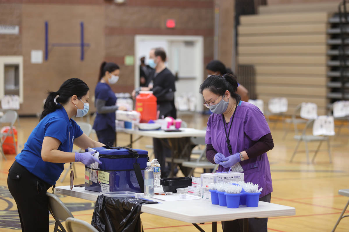 Southern Nevada Health District workers prepare for a COVID-19 pop-up vaccination clinic at Mac ...