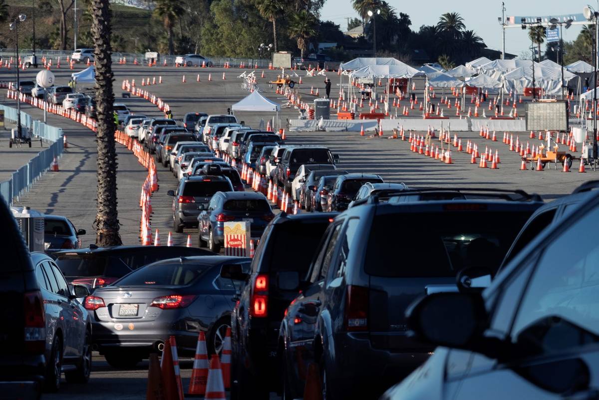 Los Angeles residents wait in line in their cars to receive a covid-19 vaccine at Dodger Stadiu ...