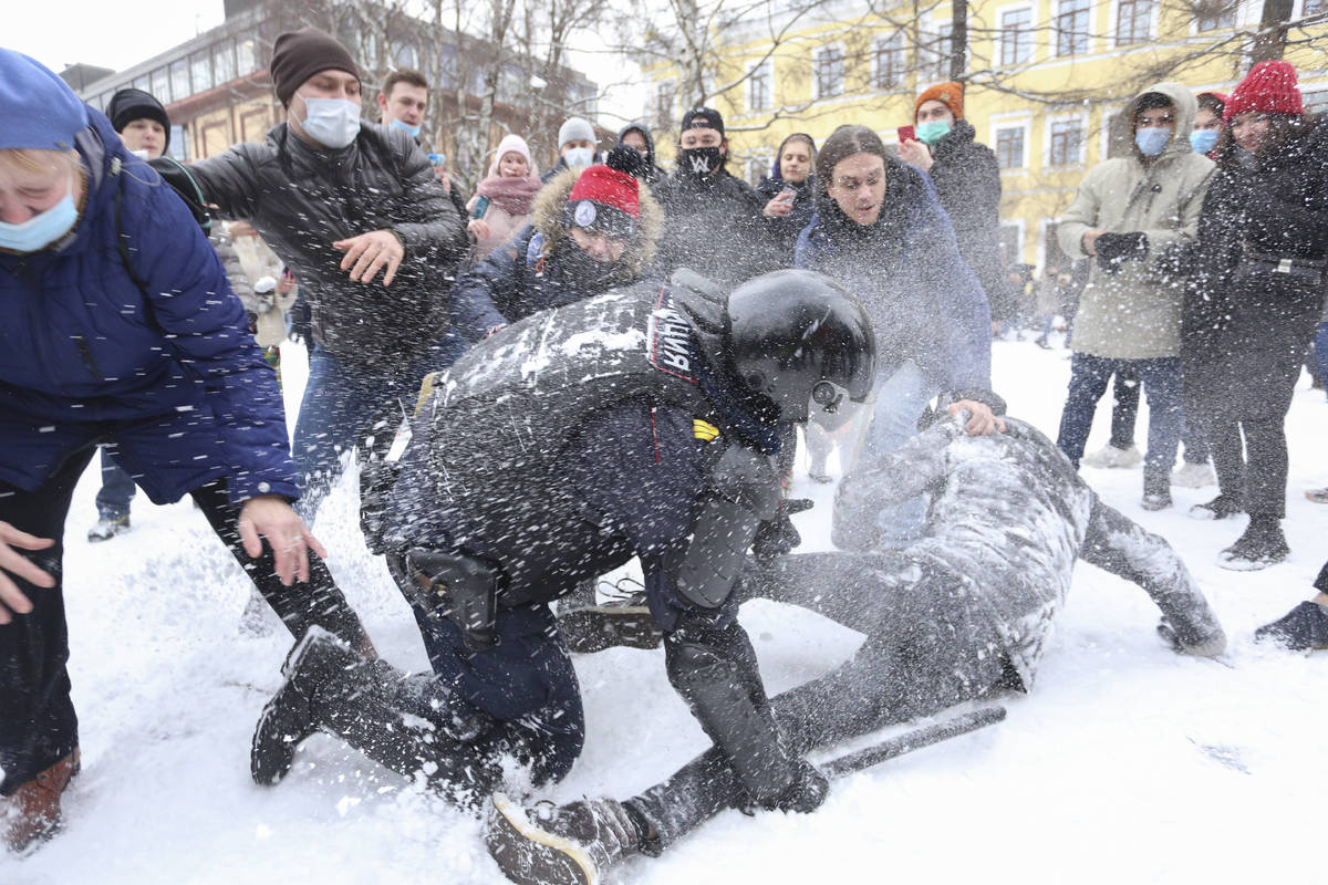 A policeman detains a man while protesters try to help him, during a protest against the jailin ...