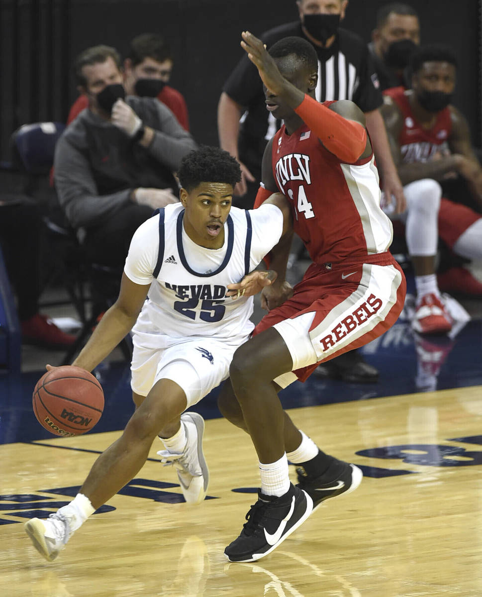 UNR's Grant Sherfield drives against UNLV's Cheikh Mbacke Diong in the first half of an NCAA co ...
