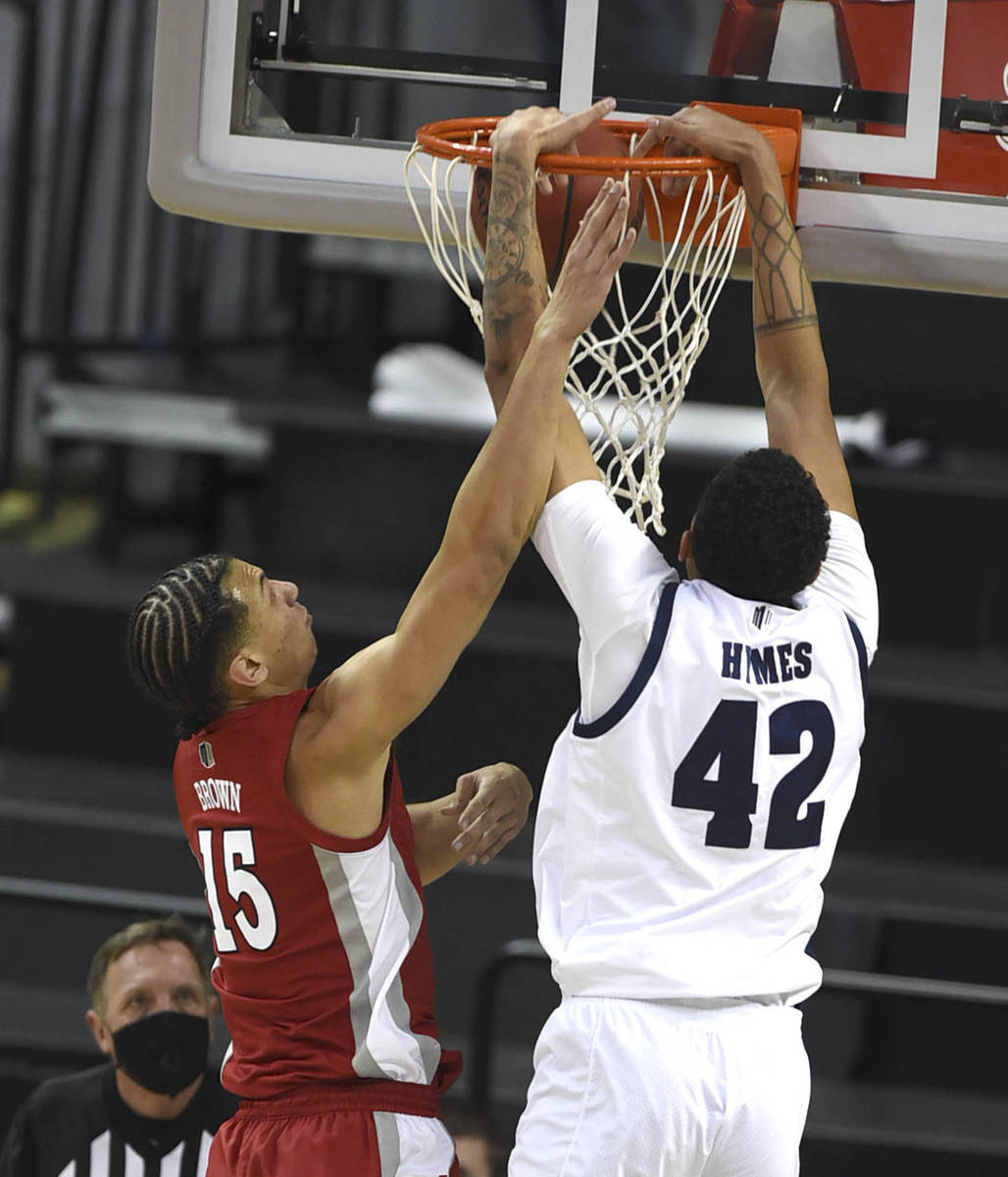UNR's Kwamé "K.J." Hymes Jr. (42) dunks against UNLV's Reece Brown in the first half of an NCA ...