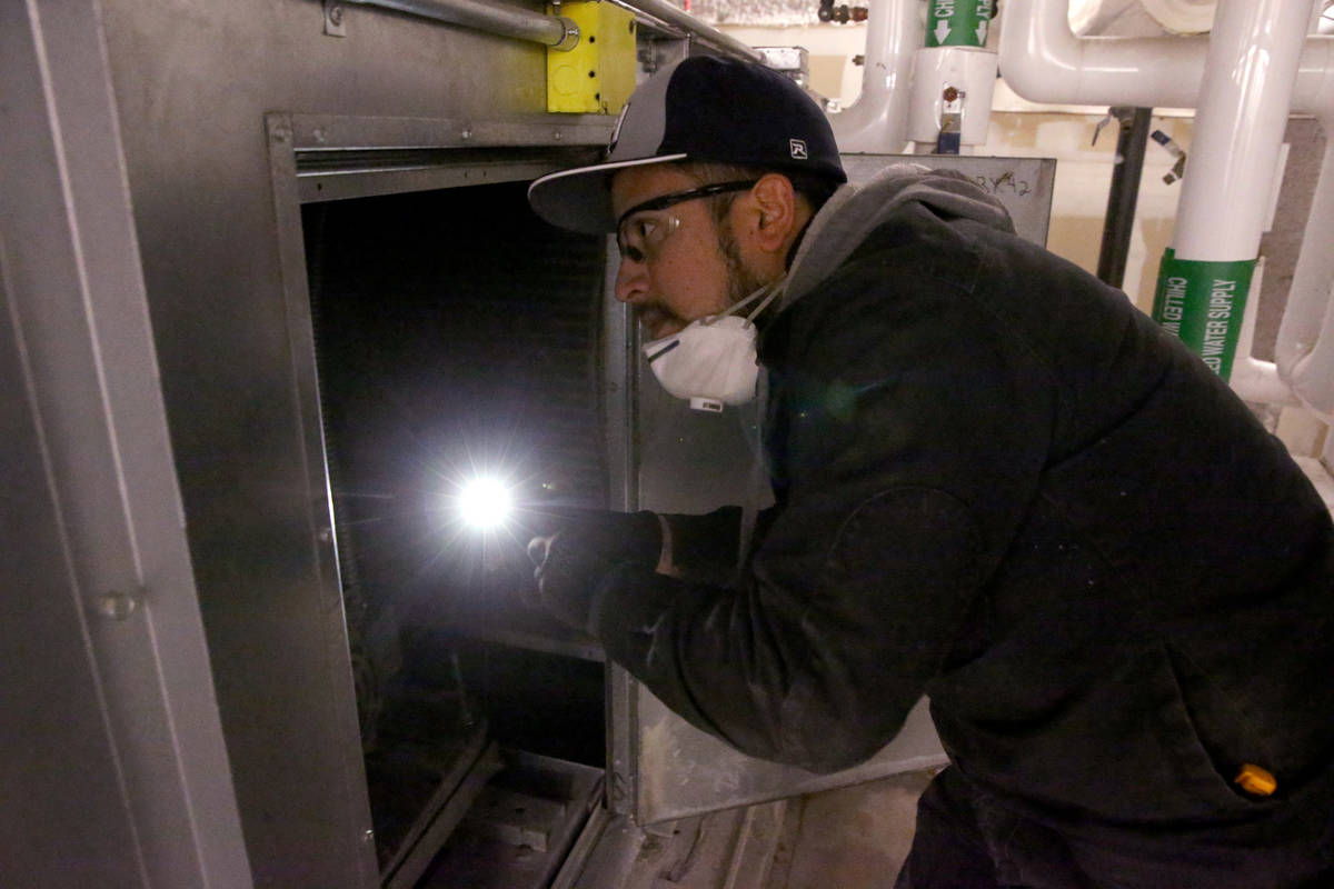 Clark County School District Building Engineer IV Juan Avila works on the heating, ventilation, ...