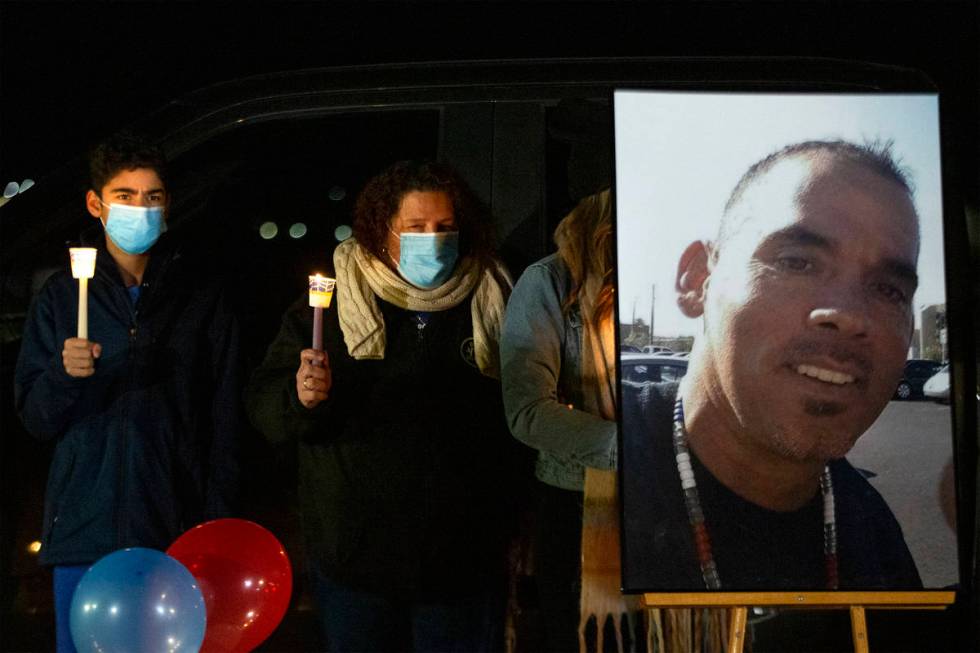 Eric Echevarria Jr., left, and his mother Annmarie Echevarria hold candles next to a photo of t ...